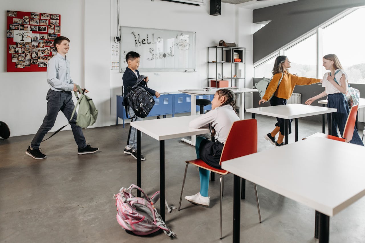 Kids chatting and settling into a modern classroom environment, showcasing school life.